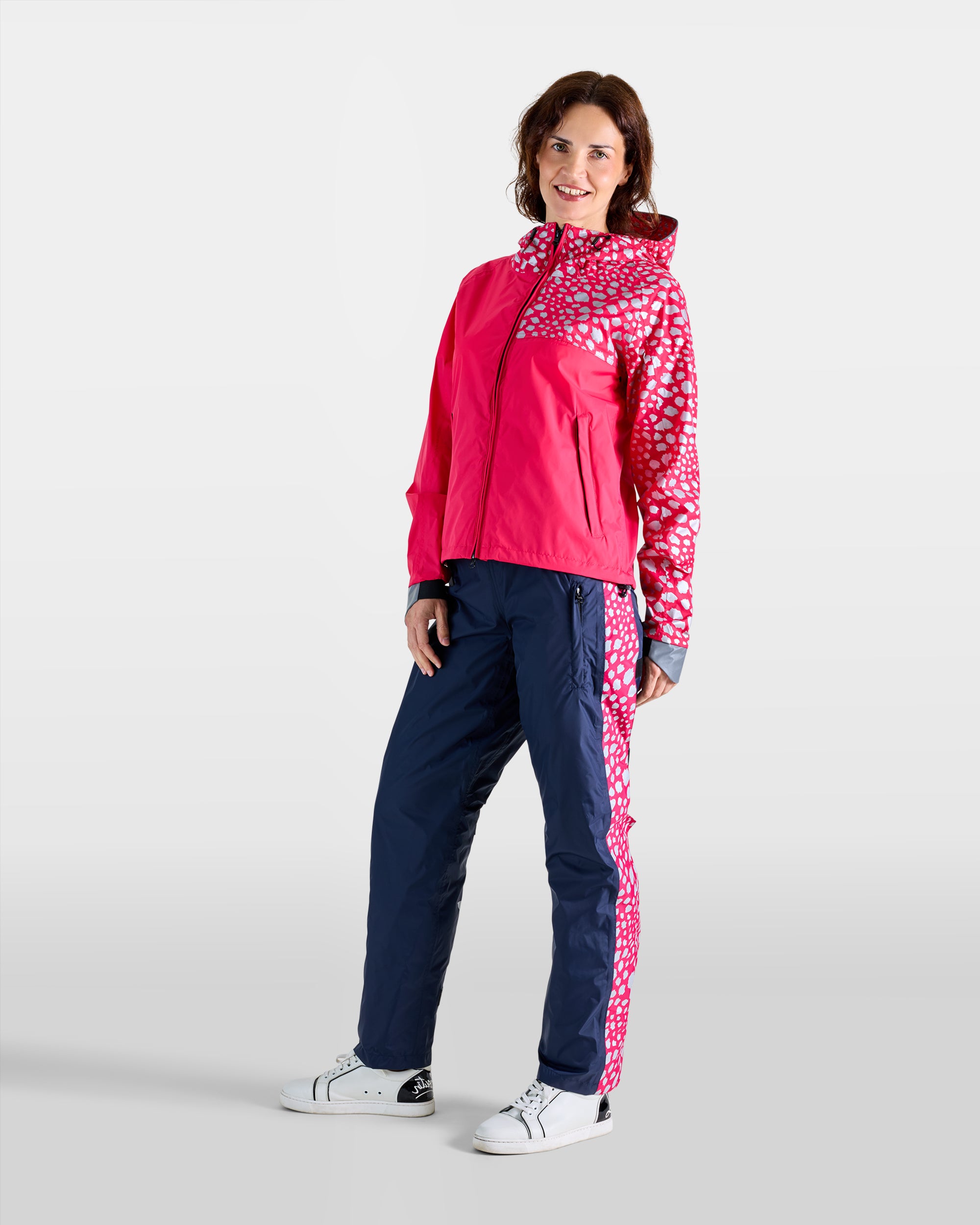Wasserdichtes Set aus Anorak und Regenüberzieher an einer Frau, marineblau und himbeerrosa mit Gepardenmuster