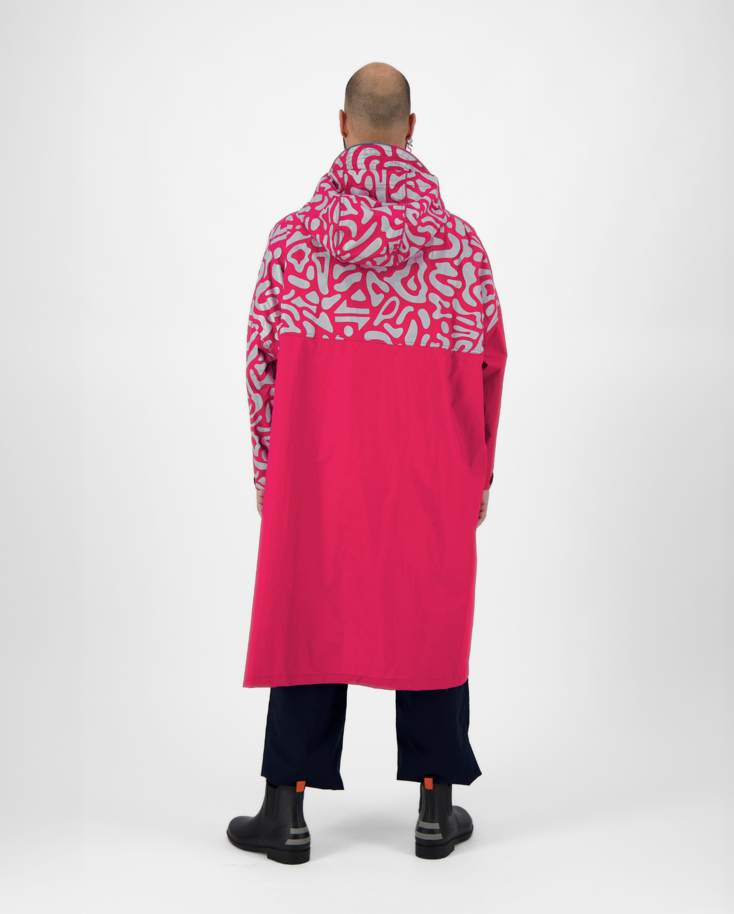 Poncho vélo framboise de dos, avec motifs graphiques réfléchissants pour mobilité urbaine.