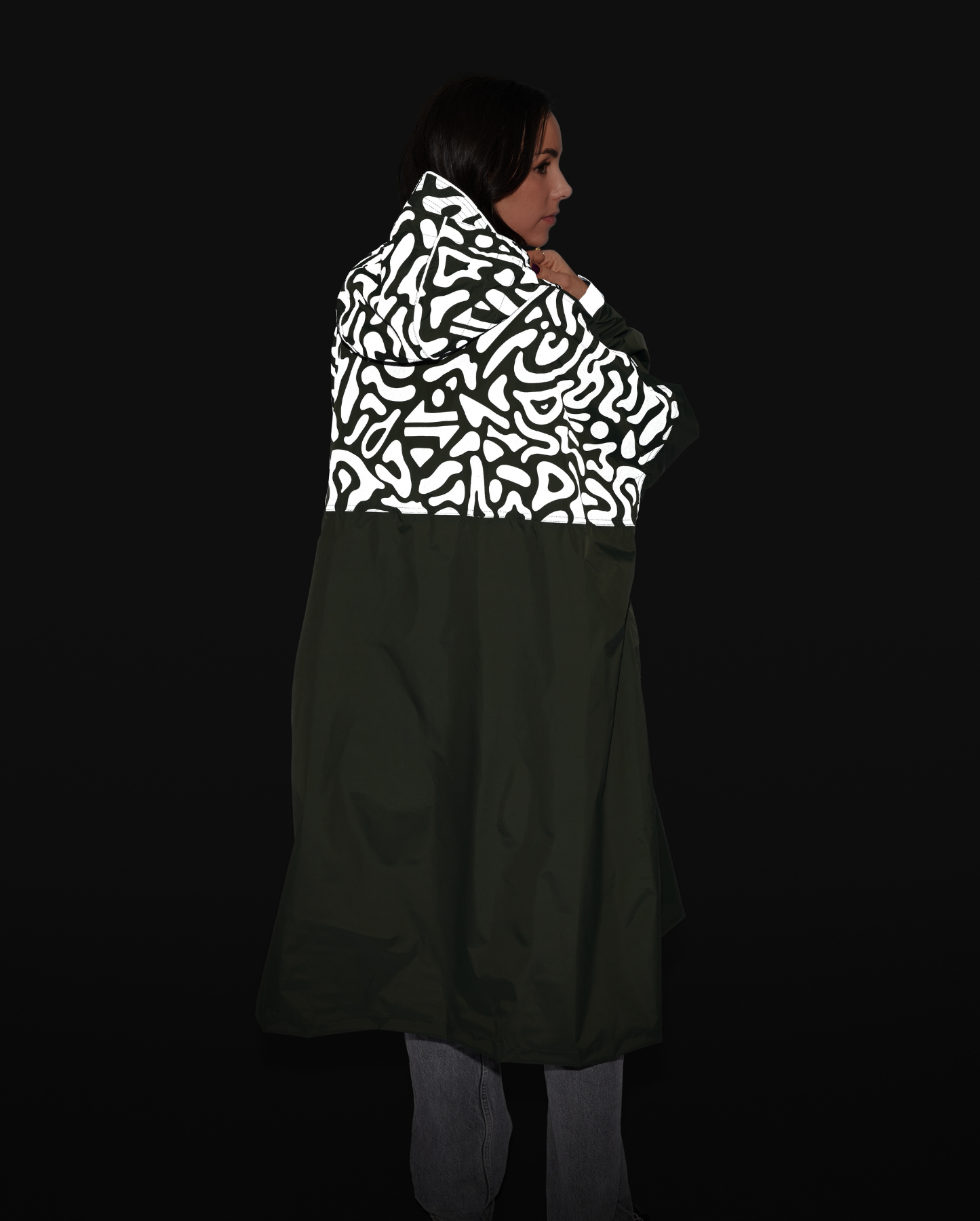 Poncho de pluie kaki pour cycliste urbaine, porté de dos, avec motifs graphiques réfléchissants