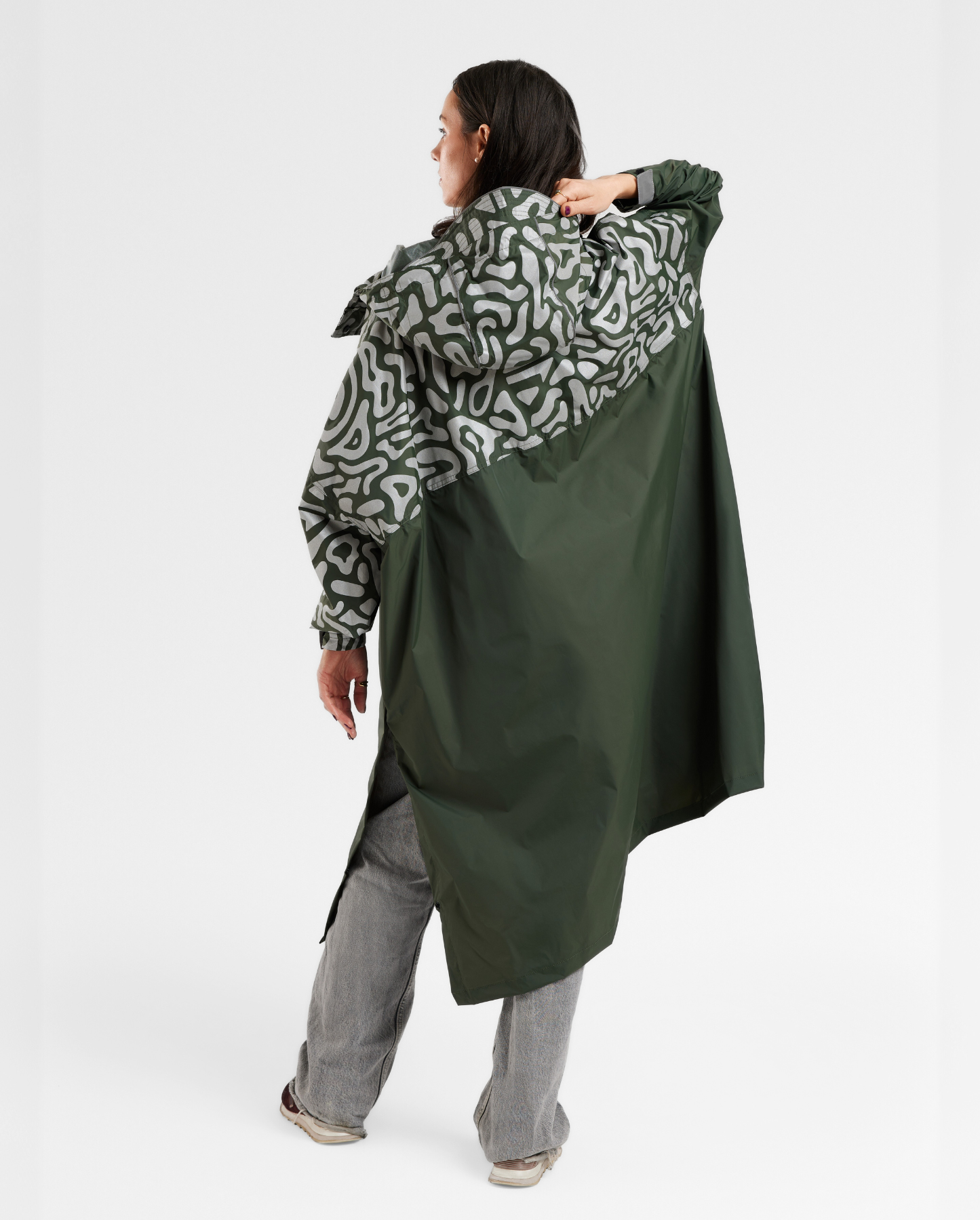 Poncho de pluie kaki pour femme, vue de dos de jour, coupe fluide et adaptée aux trajets à vélo en ville.
