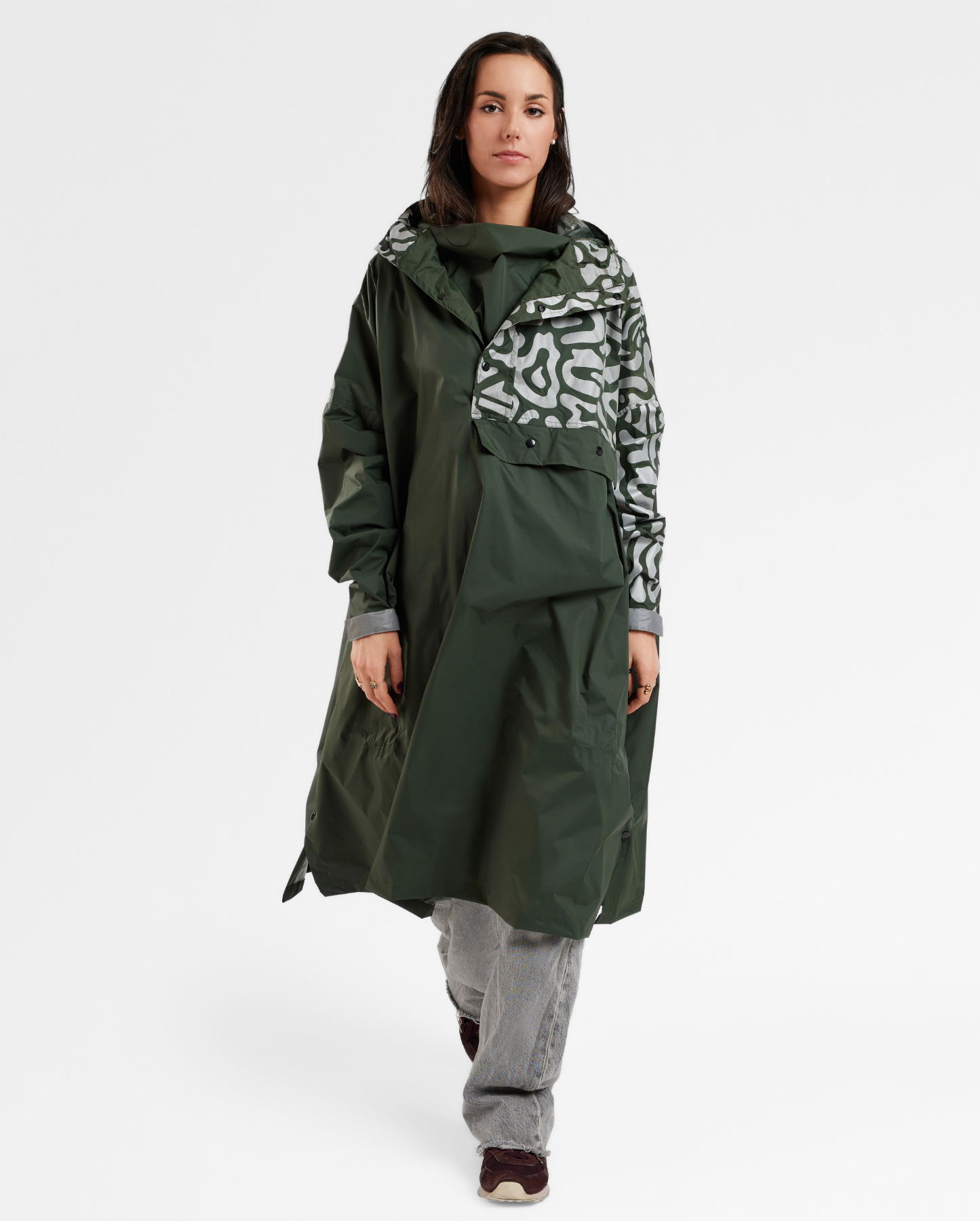 Poncho de pluie kaki pour femme, imperméable et ample, porté à vélo en ville.