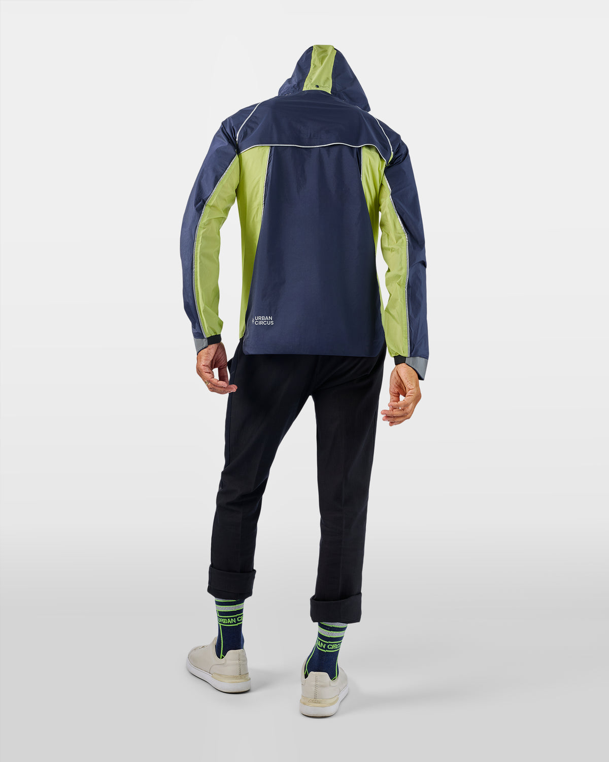 veste de sport outdoor jaune bleue marine légère respirante avec capuche sur homme de dos