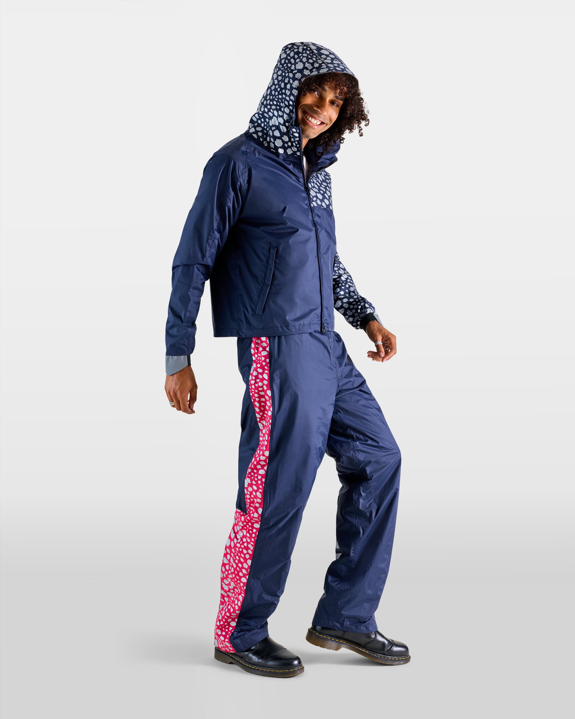 Regen-Set aus Anorak und Regenüberzieher in Marineblau und Rosa mit Gepardenmuster an einem Mann