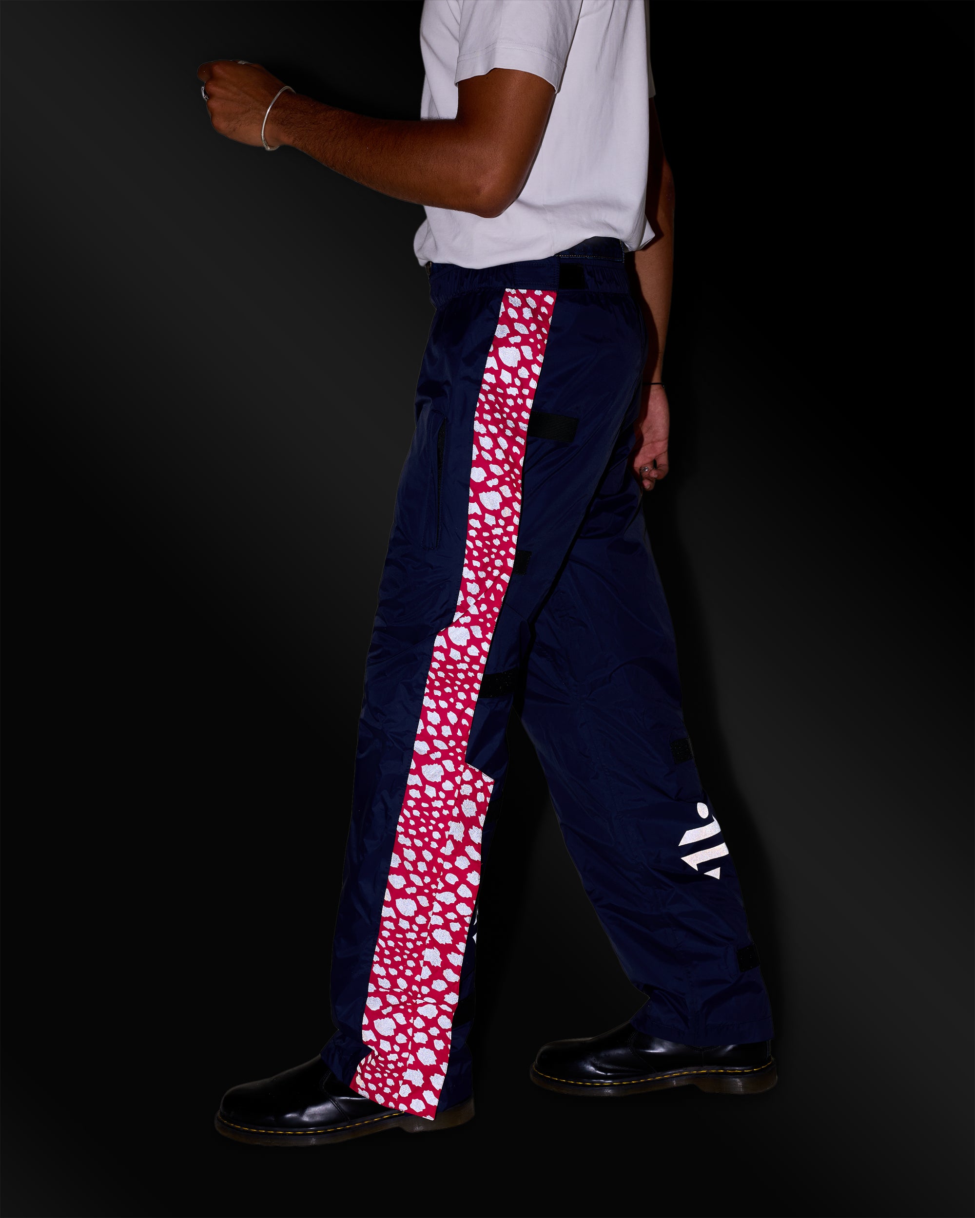 Marineblaue und rosa Regenhose mit reflektierendem Muster an einem Mann bei Nacht