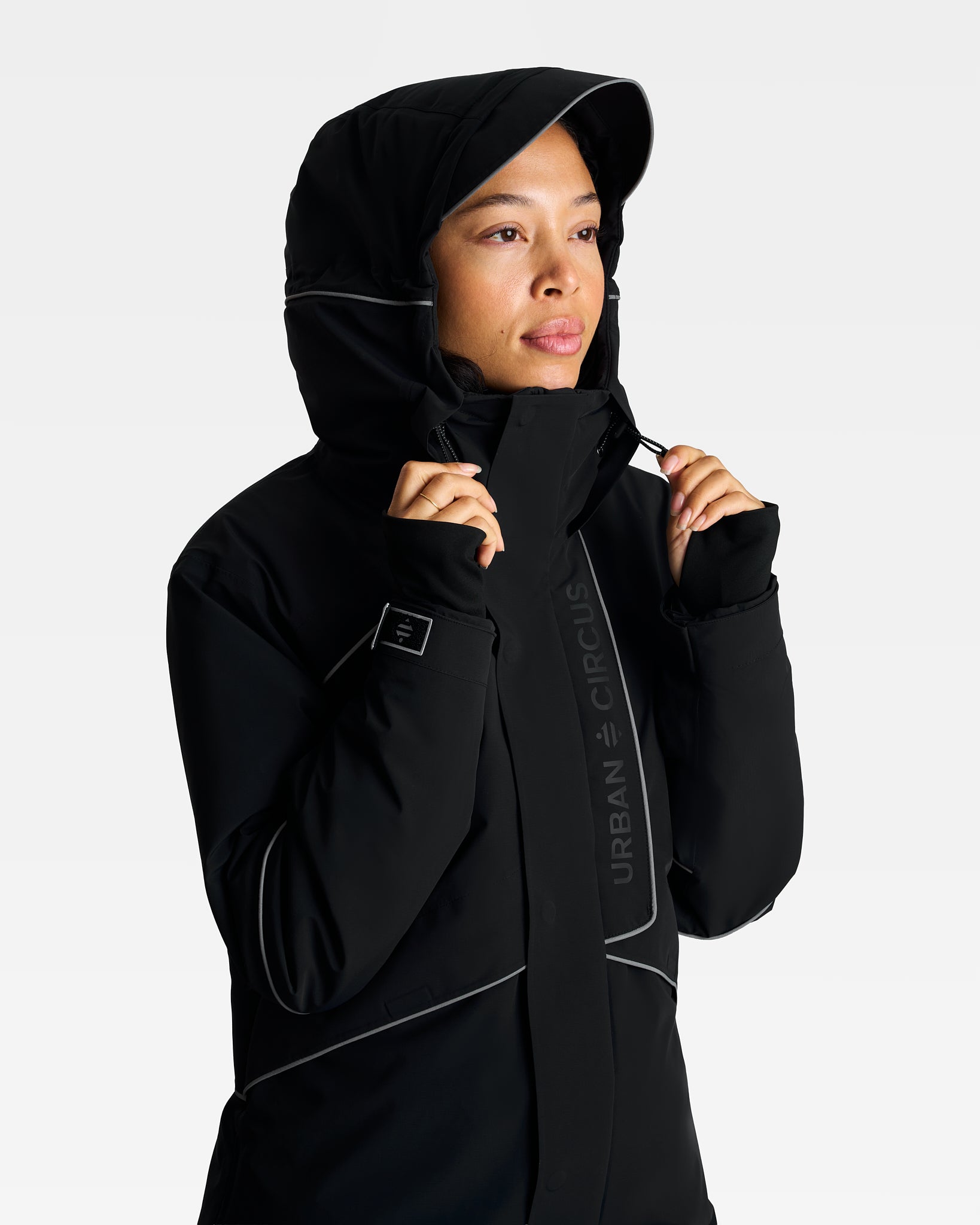 Parka noire d'hiver imperméable avec grande capuche qui passe sur le casque vélo