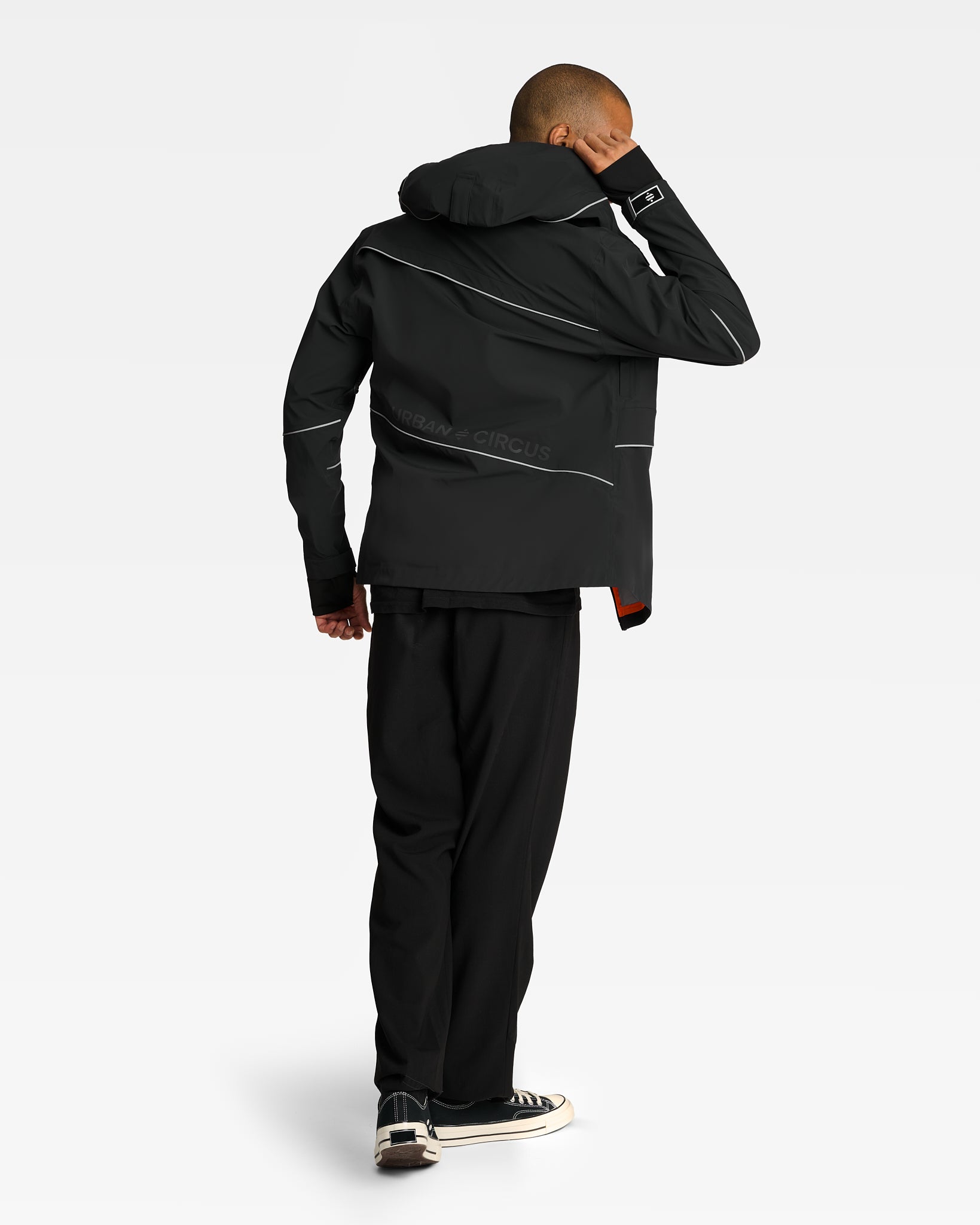 Veste ultra respirante et imperméable noire sur homme de dos